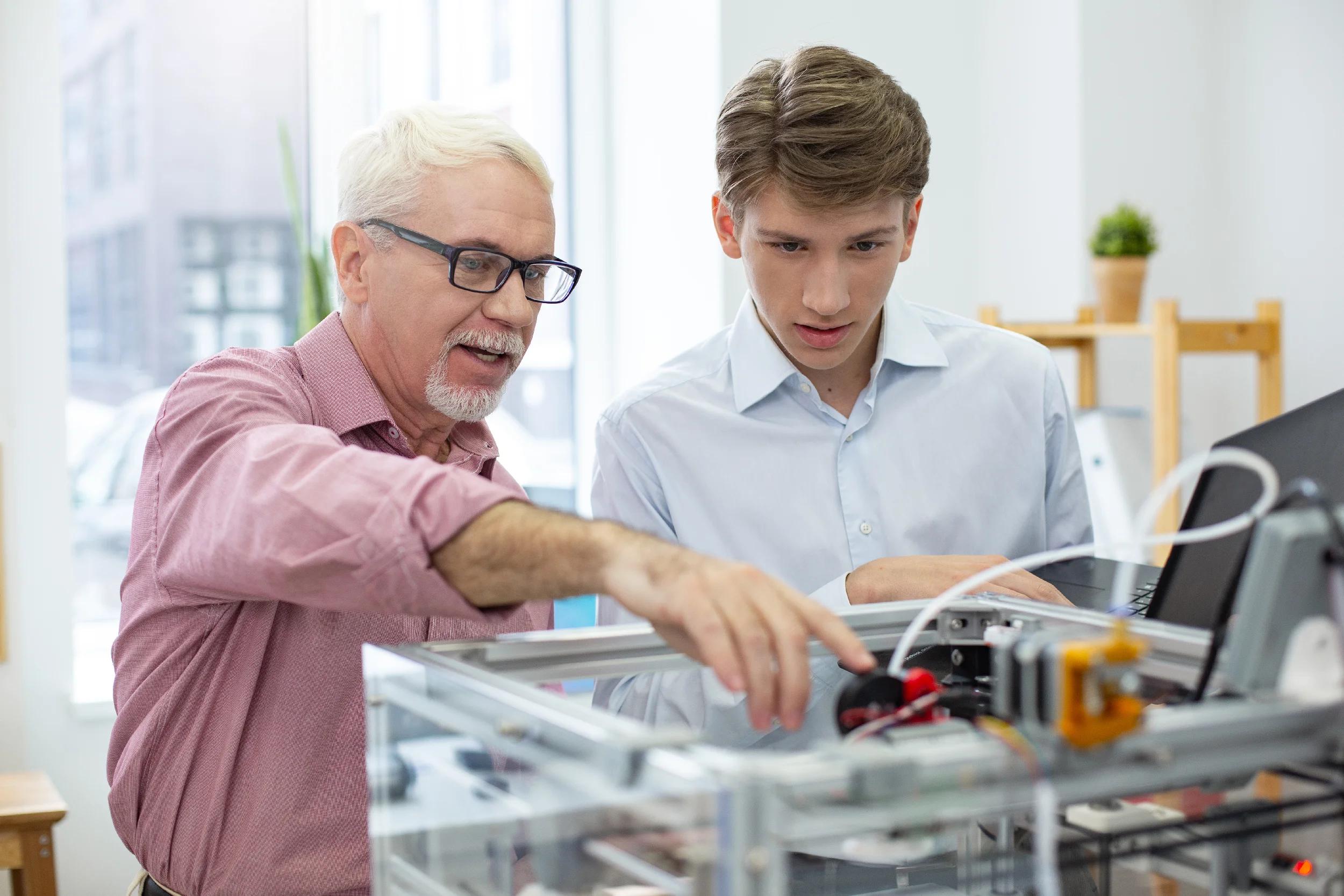 A mentor guiding an intern through hands-on technical work